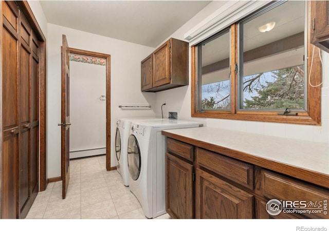 laundry area featuring washing machine and dryer, cabinet space, and baseboard heating