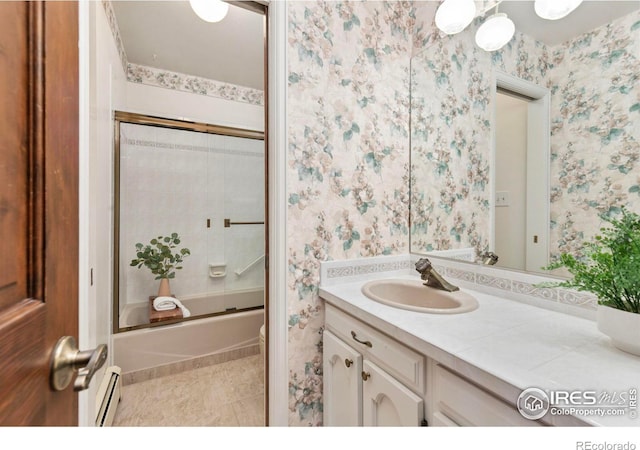 bathroom featuring tile patterned floors, wallpapered walls, baseboard heating, enclosed tub / shower combo, and vanity