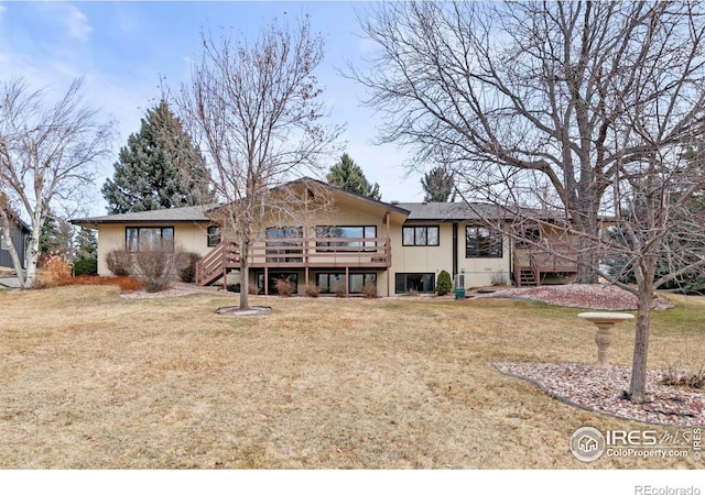 back of house with a wooden deck, a lawn, and stairs