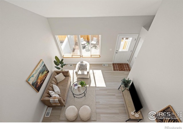 living area with visible vents, baseboards, and wood finished floors