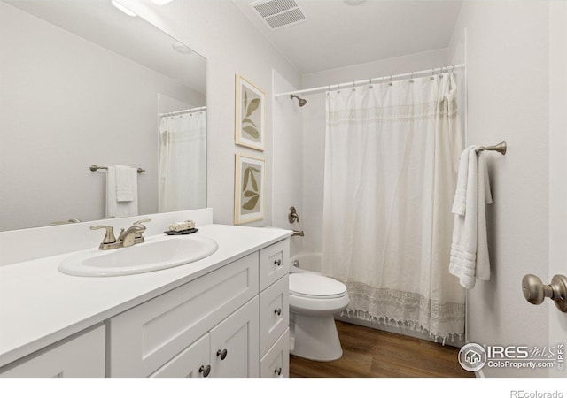 full bath featuring vanity, wood finished floors, visible vents, shower / bath combination with curtain, and toilet