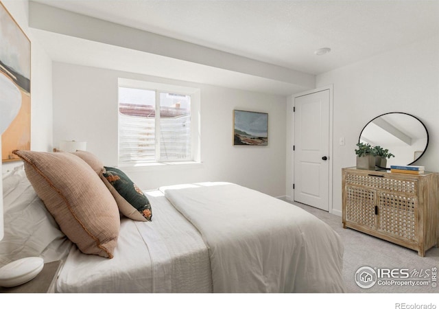 bedroom with baseboards and light carpet