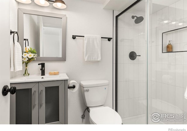 bathroom featuring a stall shower, toilet, and vanity