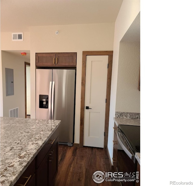 kitchen featuring electric panel, visible vents, stainless steel fridge, and black range with electric cooktop