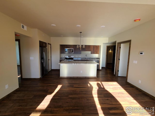 kitchen featuring visible vents, stainless steel appliances, dark wood-type flooring, and a sink