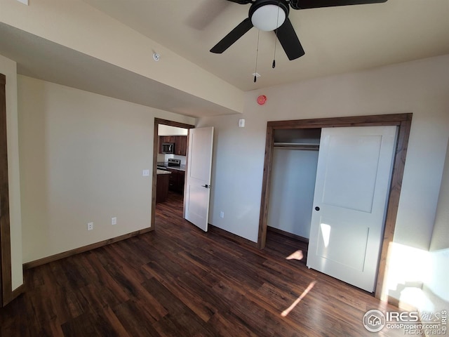 unfurnished bedroom featuring a closet, a ceiling fan, baseboards, and dark wood-style flooring