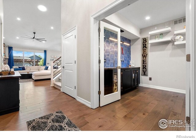 hall featuring recessed lighting, visible vents, stairway, and hardwood / wood-style flooring