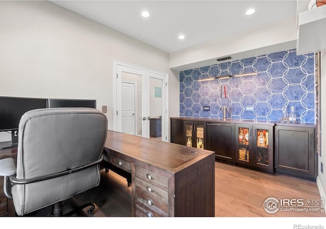 office featuring recessed lighting, an accent wall, and light wood-style floors