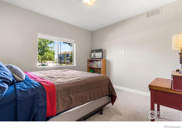 carpeted bedroom featuring visible vents and baseboards