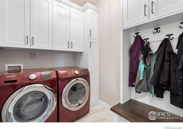 laundry room with cabinet space, baseboards, and separate washer and dryer