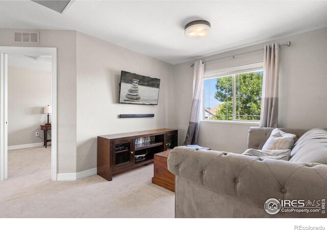 living area featuring light carpet, visible vents, and baseboards