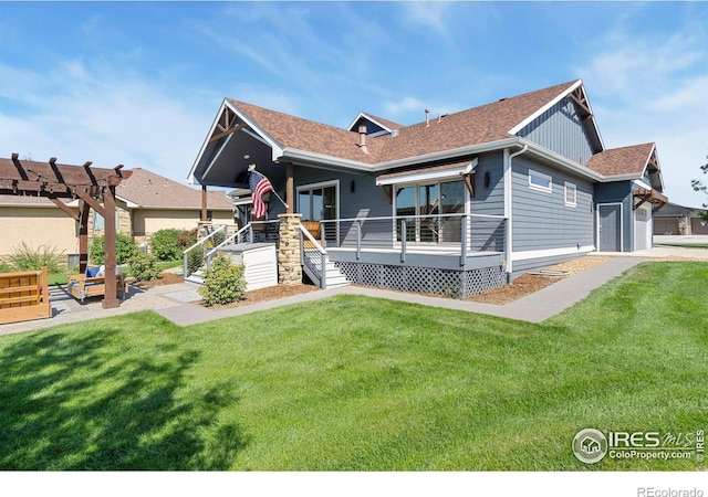 rear view of property with board and batten siding, a wooden deck, and a yard