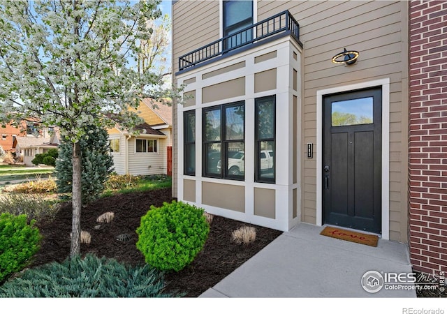 302 N Meldrum St Unit 103, Fort Collins, CO 80521 - view of exterior entry featuring a balcony and brick siding