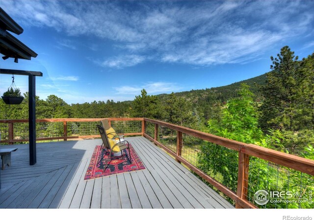 wooden deck featuring a forest view