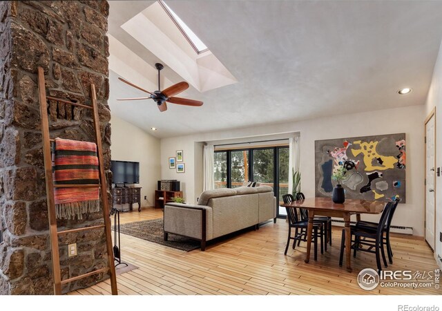 living room featuring hardwood / wood-style floors, lofted ceiling with skylight, recessed lighting, and ceiling fan