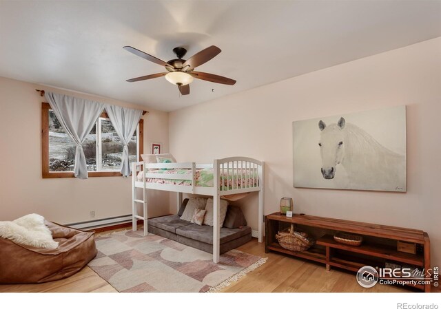 bedroom featuring a baseboard radiator and wood finished floors