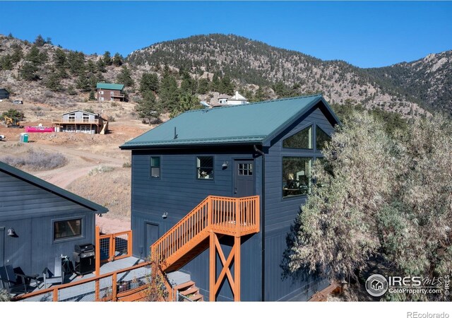 back of house featuring metal roof and a deck with mountain view