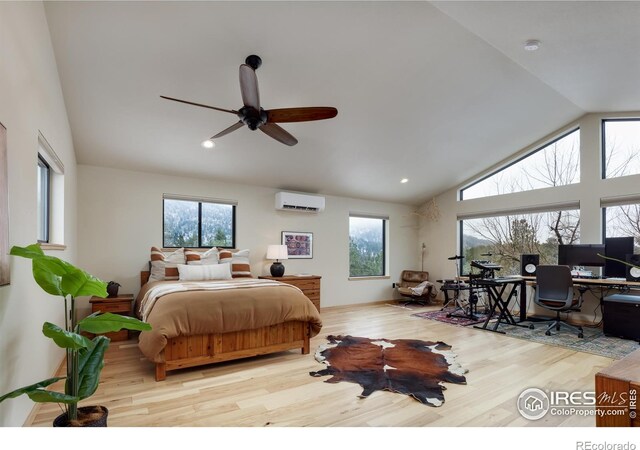 bedroom featuring multiple windows, high vaulted ceiling, wood finished floors, and a wall mounted AC