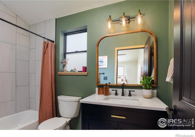 bathroom featuring toilet, vanity, a textured wall, and shower / bath combo