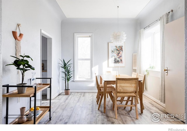 dining space featuring a notable chandelier, wood finished floors, and baseboards