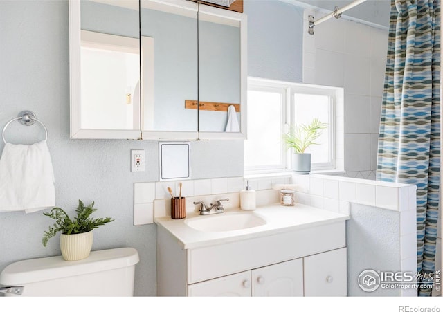 full bath with curtained shower, toilet, and vanity