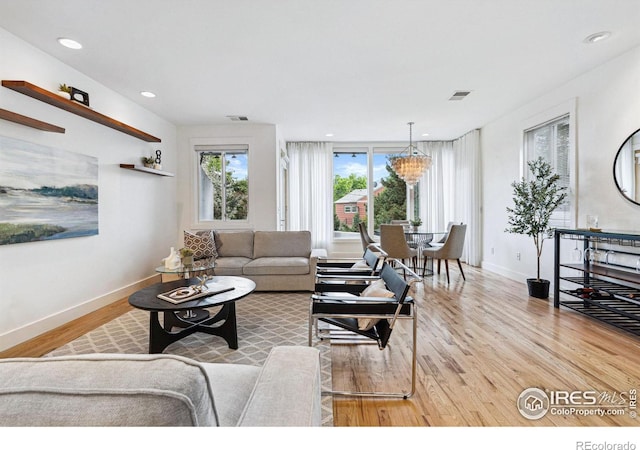 living area featuring visible vents, recessed lighting, wood finished floors, and baseboards