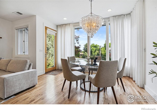 dining area with a chandelier, visible vents, baseboards, and wood finished floors