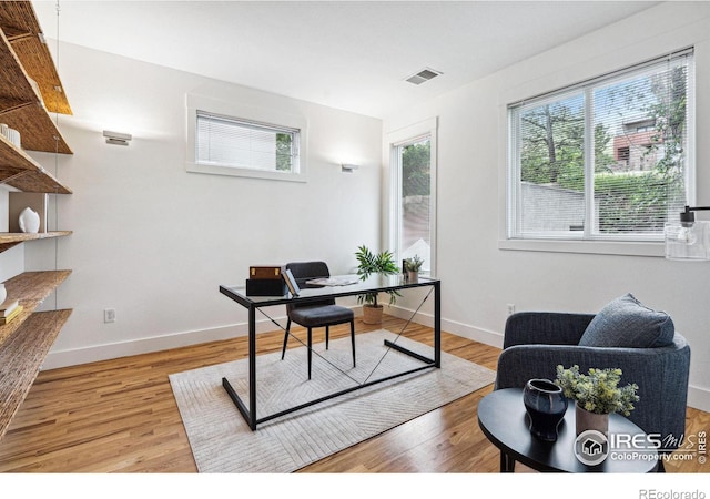 office with visible vents, baseboards, and light wood-style flooring