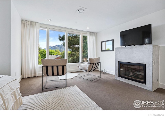 carpeted bedroom with a glass covered fireplace, recessed lighting, and baseboards