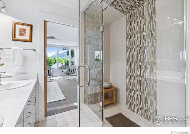 bathroom featuring a sink, double vanity, a stall shower, and tile patterned floors