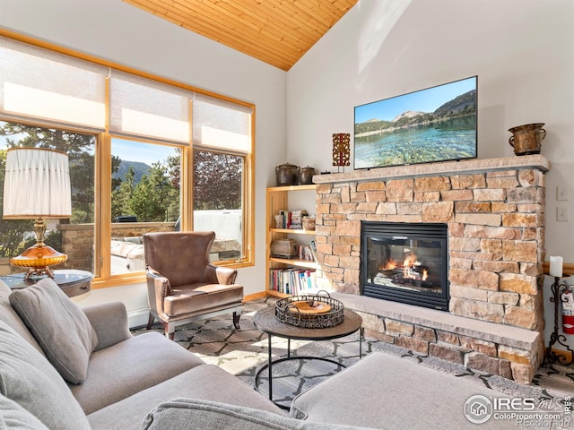 living area with baseboards, wooden ceiling, a fireplace, and vaulted ceiling