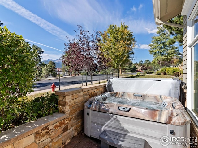 view of patio featuring a mountain view and a hot tub