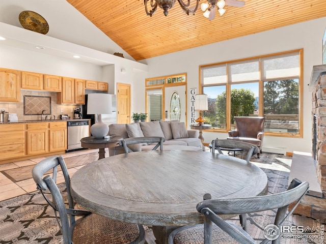 dining room featuring stone tile flooring, high vaulted ceiling, and wood ceiling