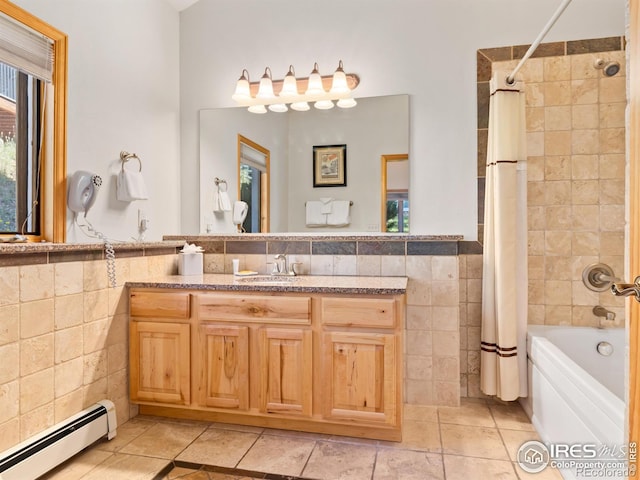 bathroom featuring a wealth of natural light, a baseboard heating unit, and tile walls