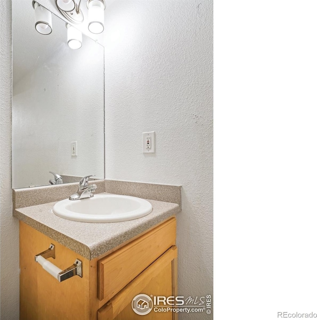 bathroom with vanity and a textured wall