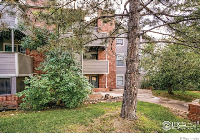 view of front of home featuring brick siding and a balcony