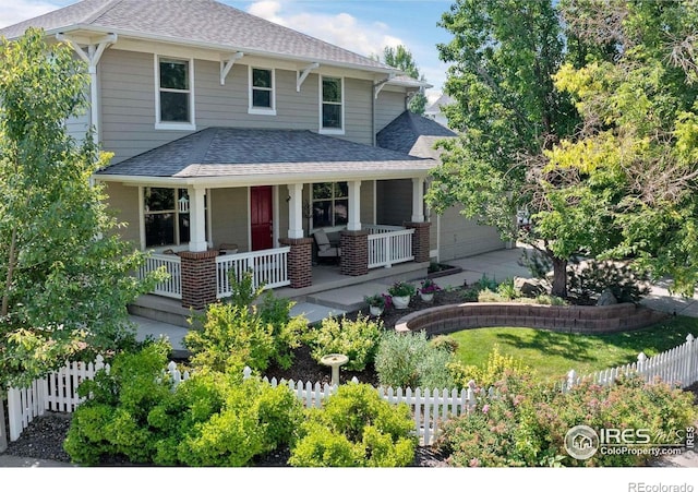 view of front of home with roof with shingles, a porch, and fence