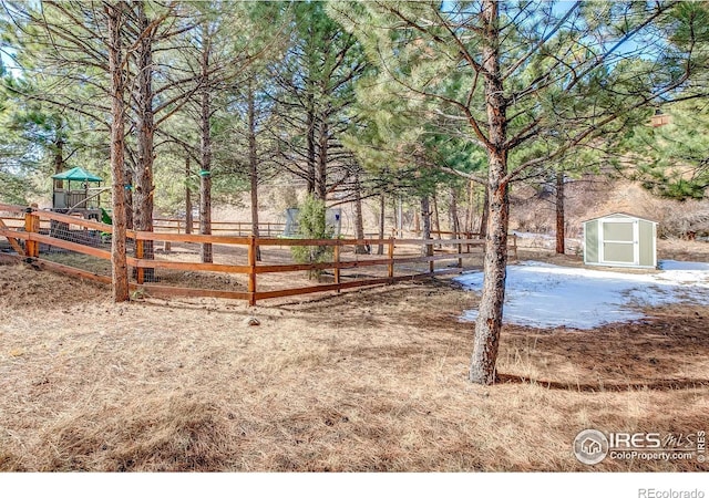 view of yard with a storage shed, an outbuilding, and fence