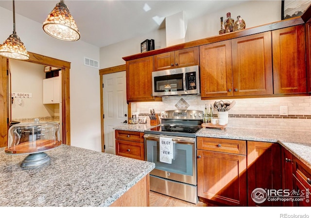 kitchen with visible vents, backsplash, pendant lighting, brown cabinets, and appliances with stainless steel finishes