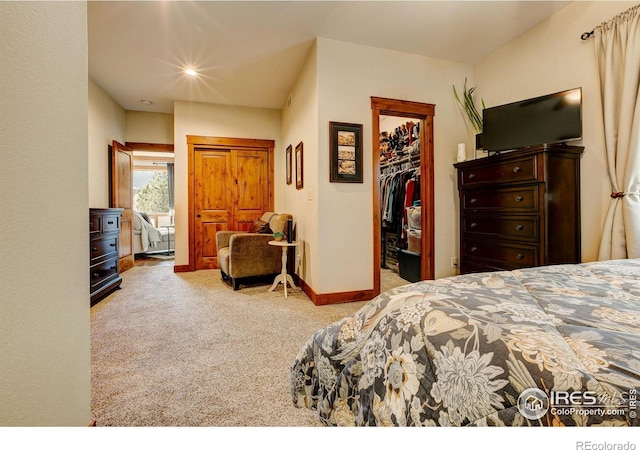 bedroom with a walk in closet, carpet floors, baseboards, and a closet