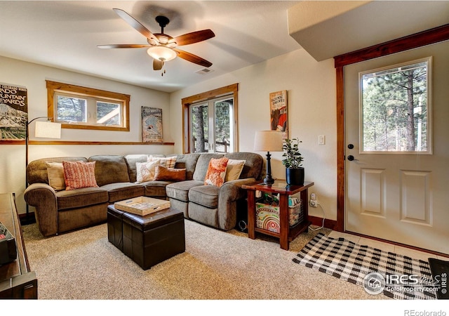 carpeted living room with baseboards, visible vents, and ceiling fan