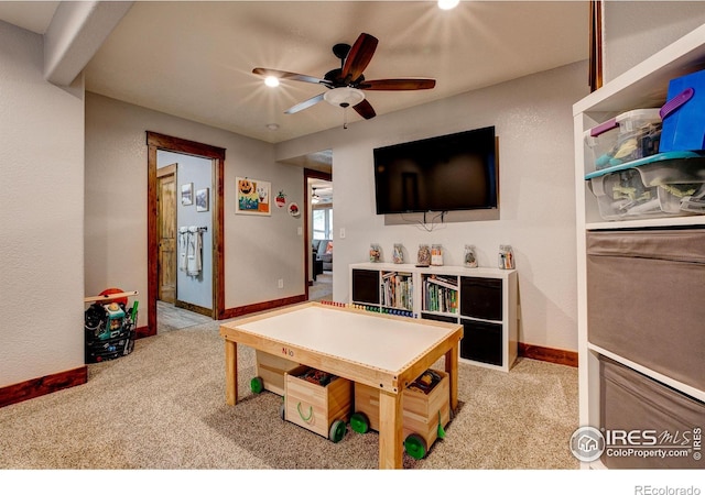 playroom featuring ceiling fan, baseboards, and light carpet