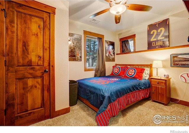 carpeted bedroom with visible vents, baseboards, and ceiling fan