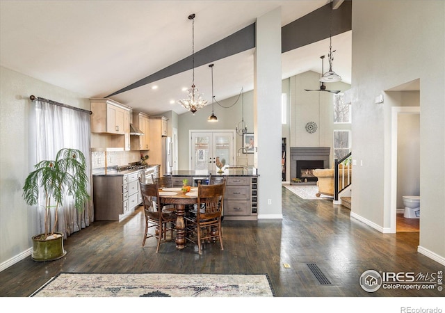 dining space with dark wood-style floors, visible vents, baseboards, high vaulted ceiling, and a fireplace