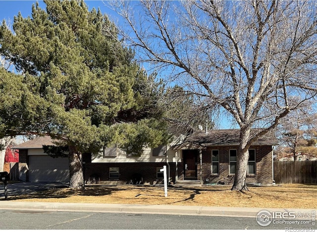 view of front of house with brick siding and fence