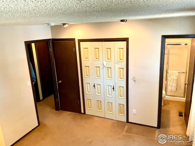 unfurnished bedroom with visible vents, carpet floors, and a textured ceiling