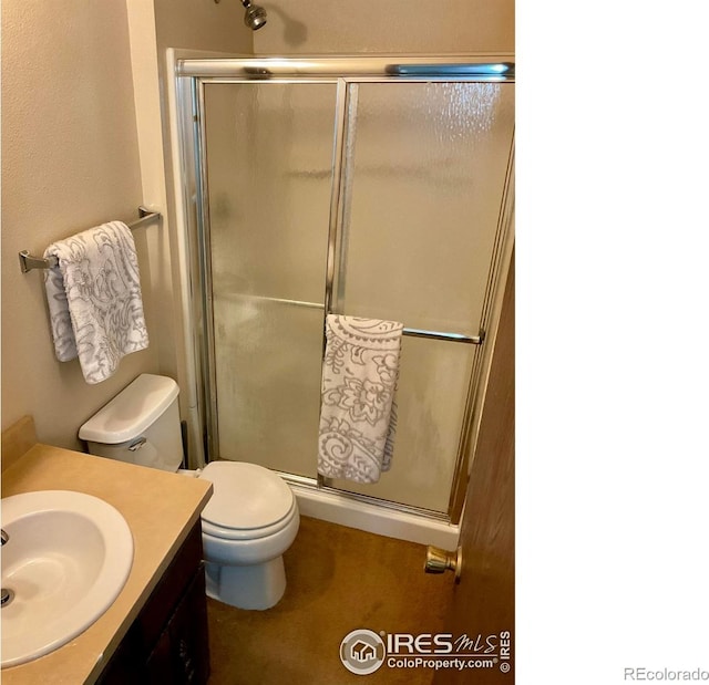 full bathroom with toilet, a stall shower, and vanity