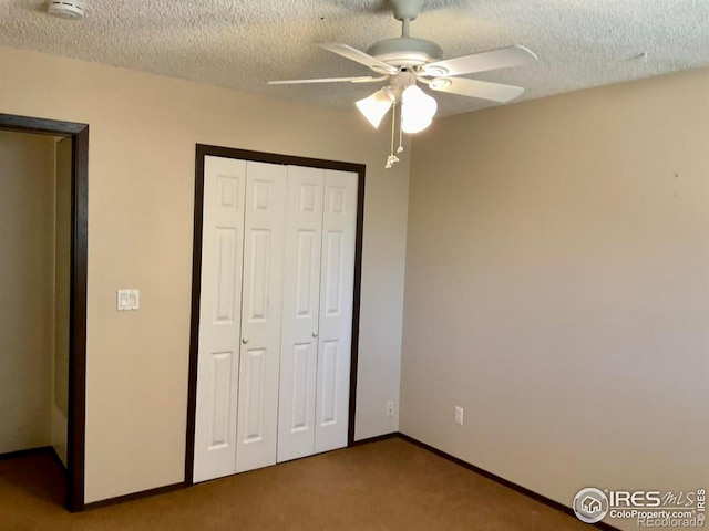 unfurnished bedroom with a ceiling fan, a textured ceiling, a closet, carpet flooring, and baseboards