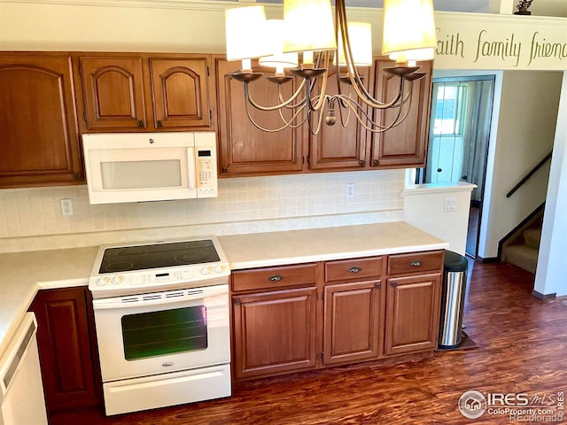 kitchen with white appliances, light countertops, dark wood-type flooring, and a chandelier