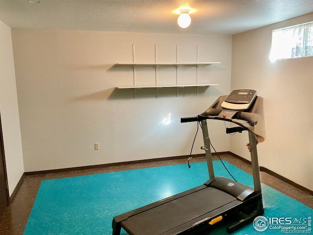 workout room with baseboards and a textured ceiling